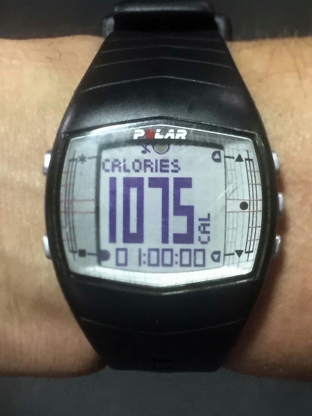 A heart-rate monitor watch reading 1,075 calories over a session time of one hour exactly.